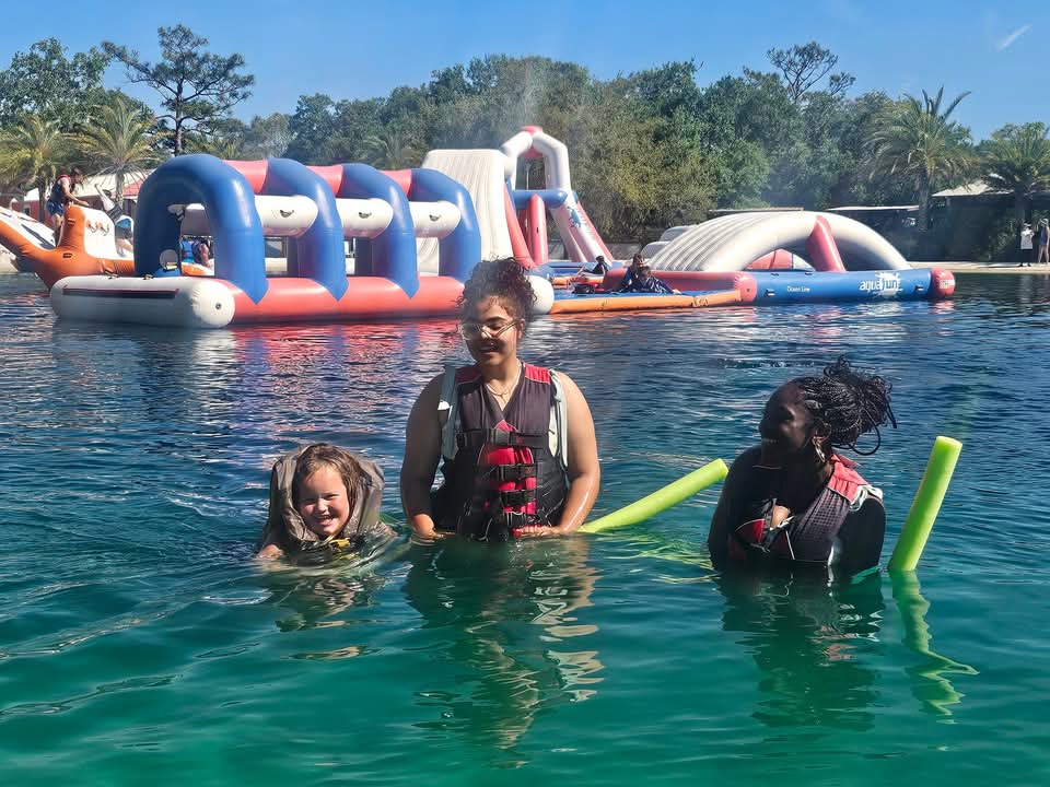 Three people enjoying the water park in life jackets at Camp Impact